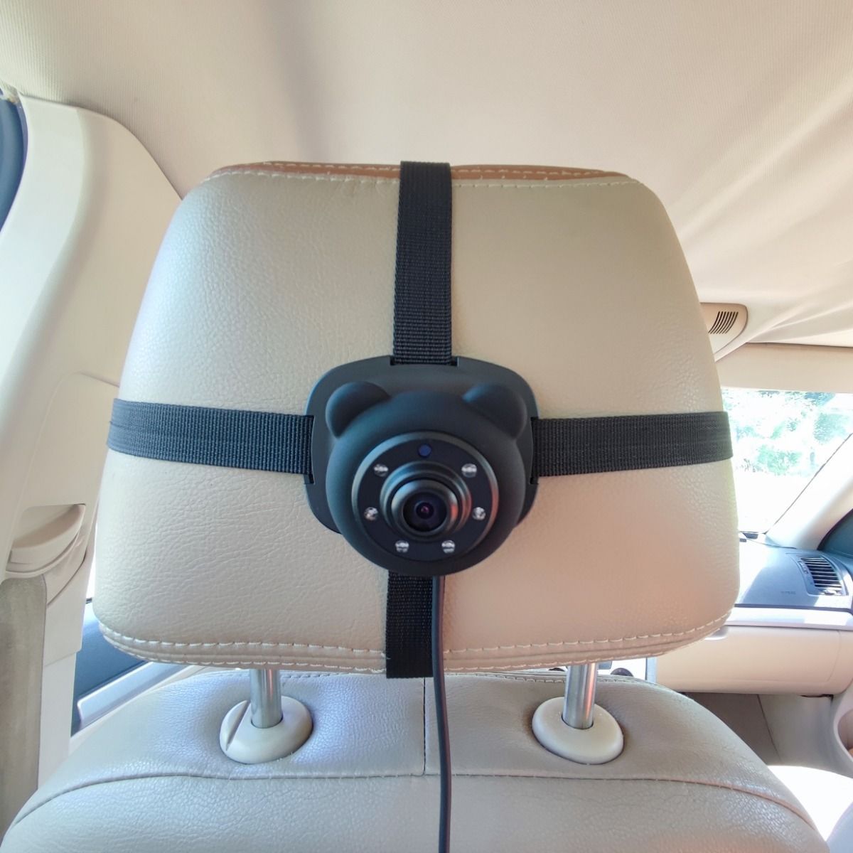 Car headrest camera mounted on a car seat with straps