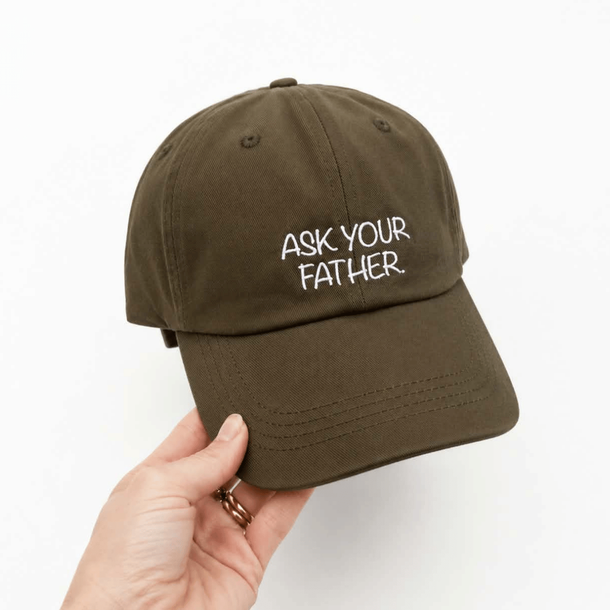 Cotton baseball cap in brown with the words 'ask your father' on it. 