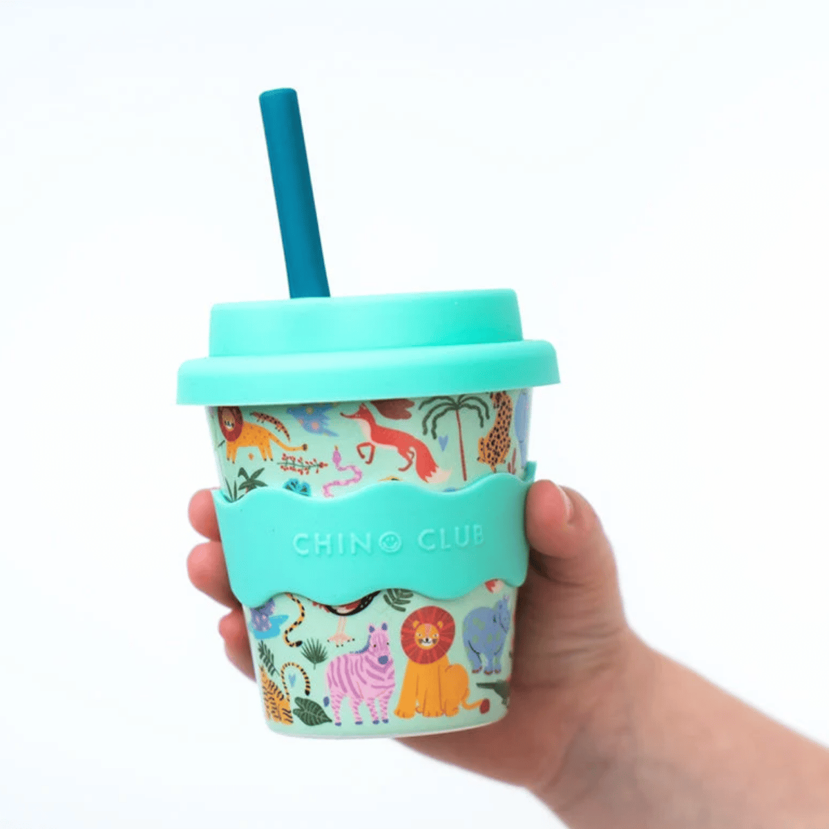 A hand holding a reusable travel tumbler with a turquoise lid and straw, featuring a colorful safari animal print and a matching turquoise silicone sleeve with the brand name CHINO CLUB.