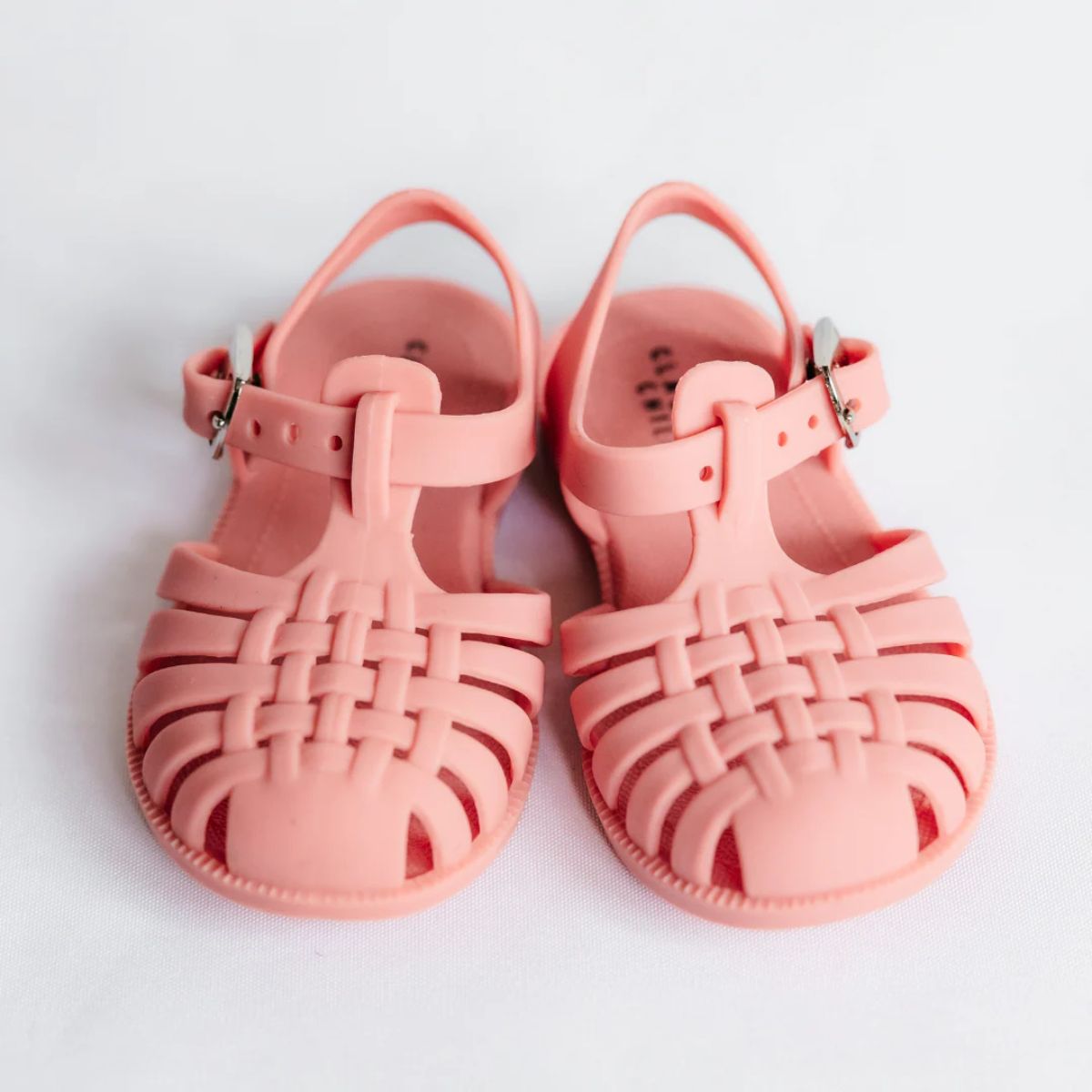 Pair of pink jelly sandals on a light gray background