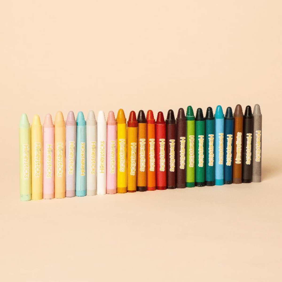 A set of 24 crayons in various colors, arranged in a neat row. Each crayon features a gold foil label with the text 'Honeycomb Crayons' printed vertically.