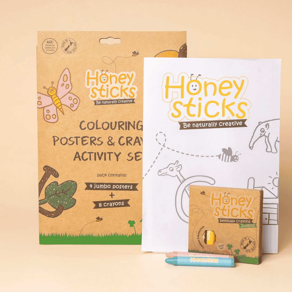 Honey Sticks Be Naturally Creative Colouring Posters & Crayons Activity Set, featuring a brown kraft paper poster pack, a white crayon coloring page, a small crayon box, and two crayons on a beige background.
