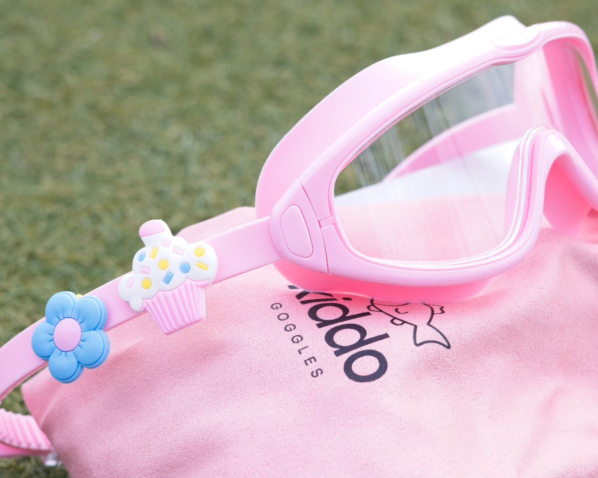 Pink goggles with decorative elements on a pink background