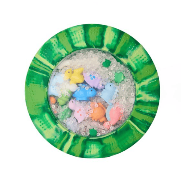 Colorful rubber duck toys in a green and white sensory mat  with water beads on a white background