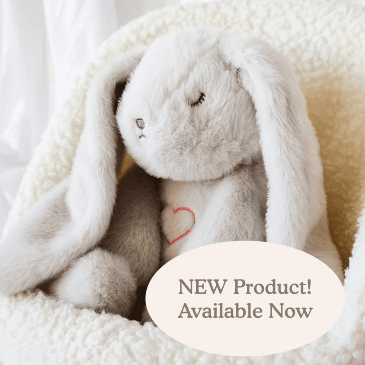 Plush bunny toy with a heart on a soft white background, featuring text 'NEW Product! Available Now'.