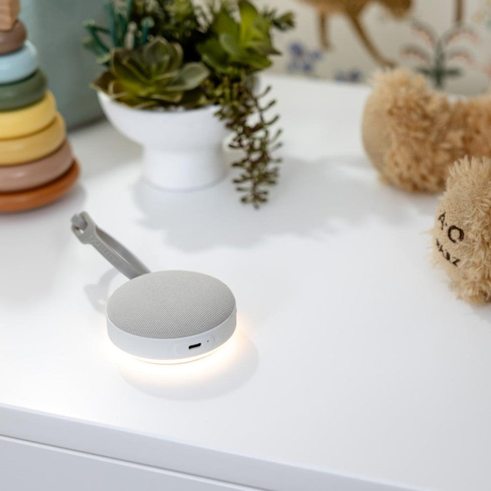 White wireless charging pad on a white surface with toys and plants in the background