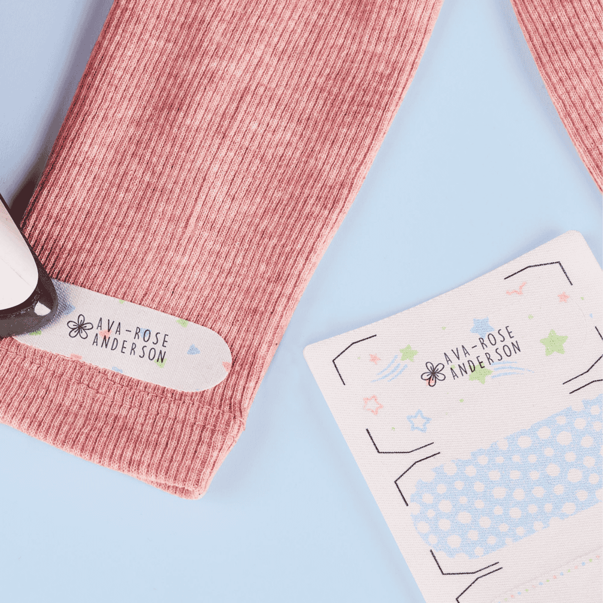 Pink ribbed socks with 'Ava-Rose Anderson' branding on a light blue background