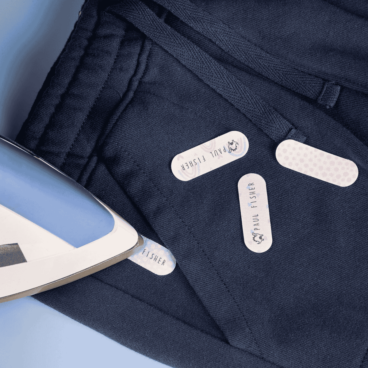 Navy blue fabric with iron and labels on a light blue background