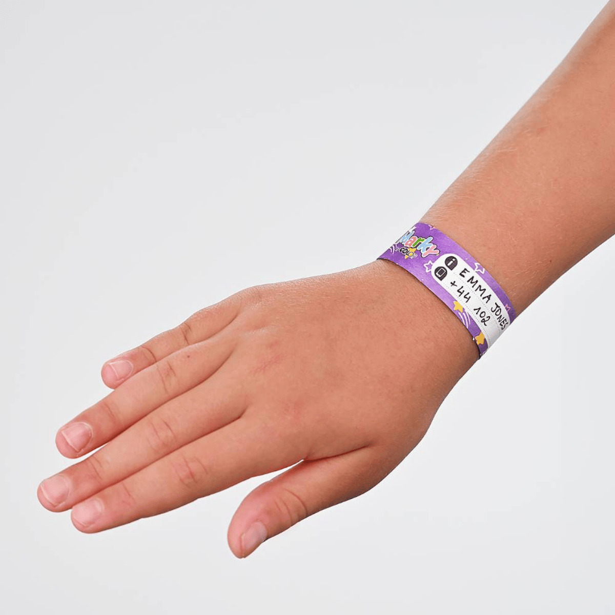 Child's hand wearing a purple wristband with text on a light gray background