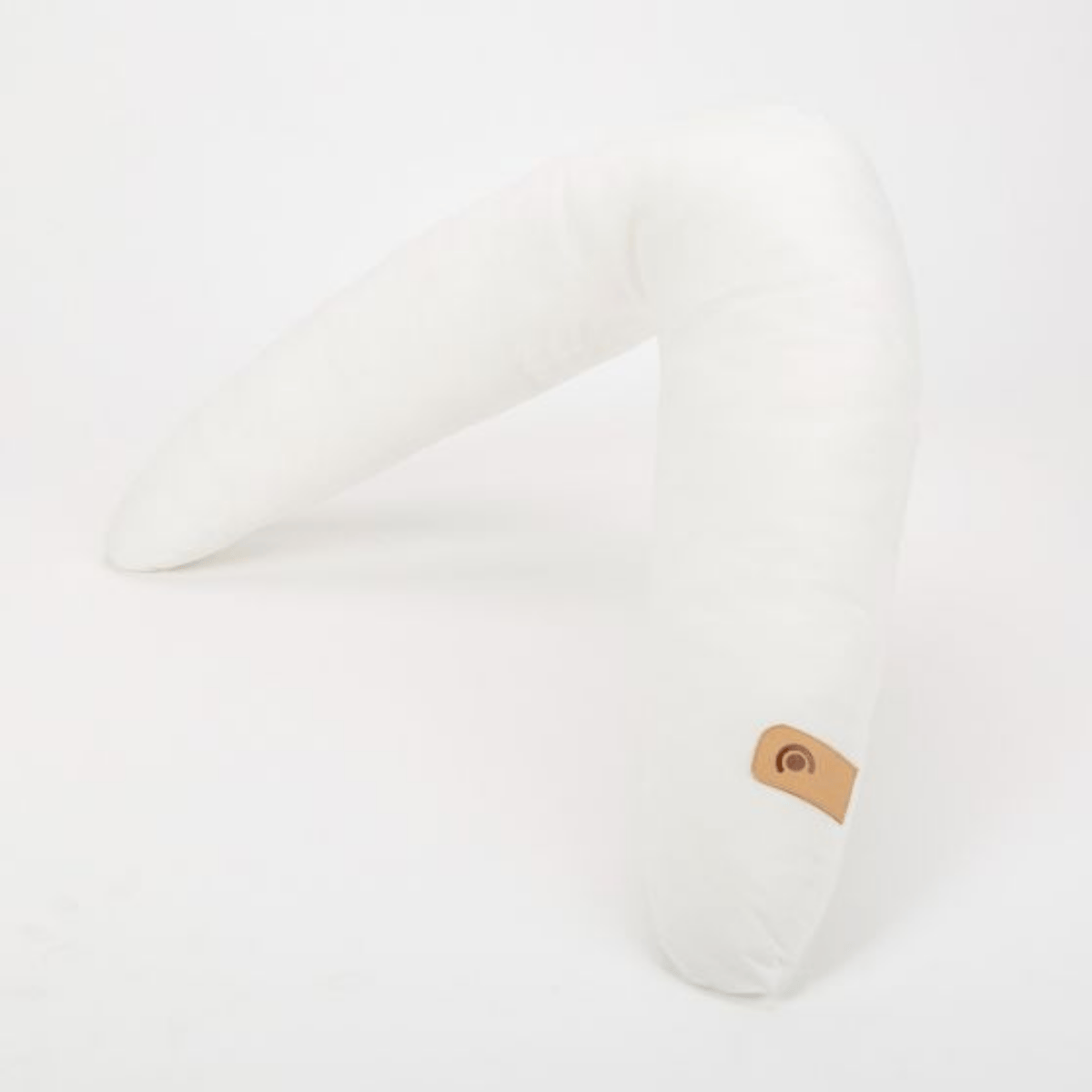 White pillow with a brown leather tag on a white background