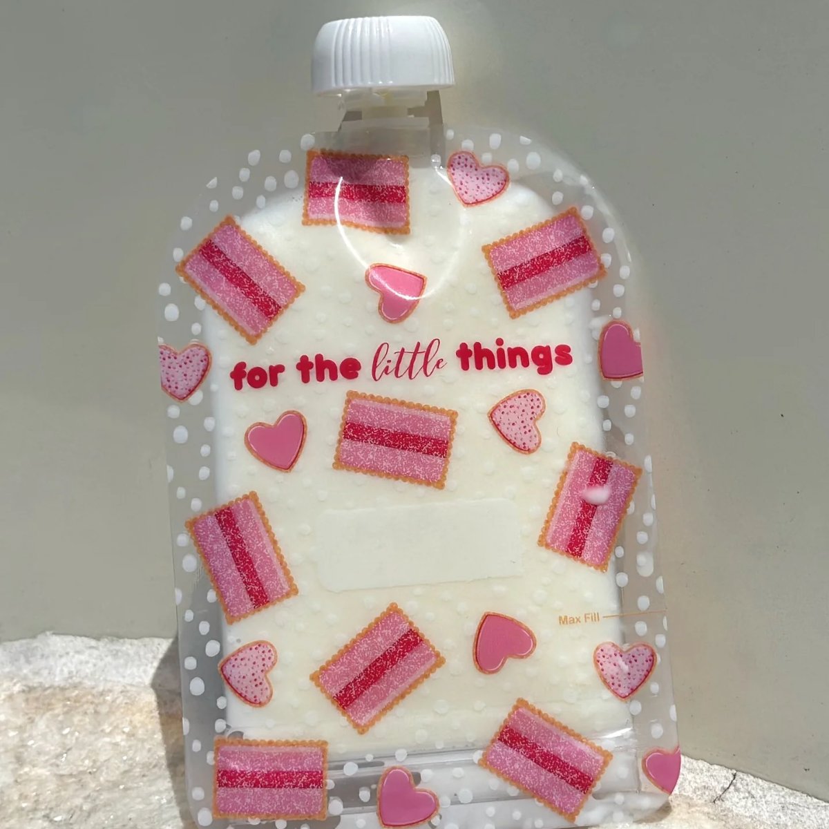 Plastic bottle with pink and red heart-shaped decorations and text on a white background