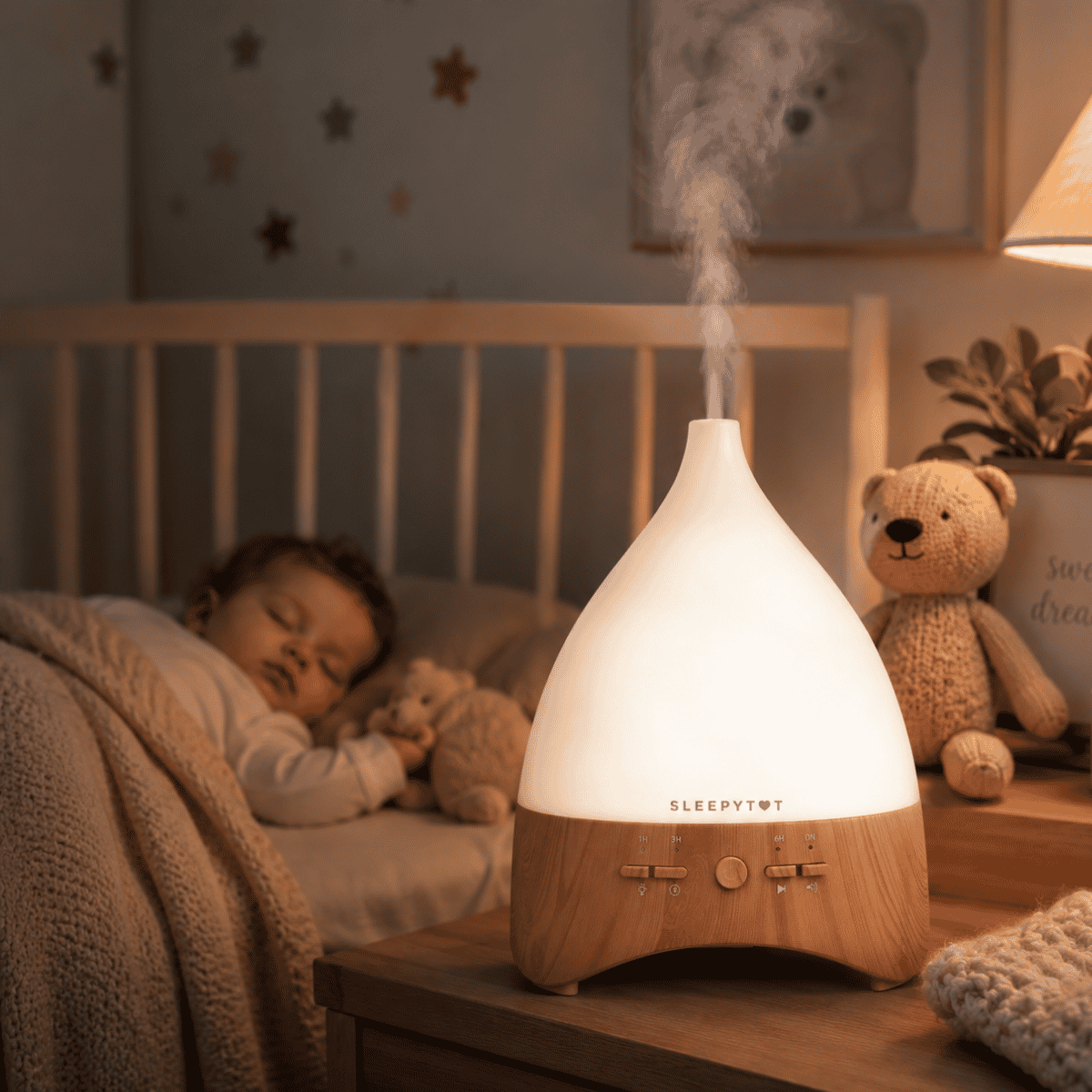 Child sleeping in a crib with a teddy bear next to an essential oil diffuser on a nightstand.