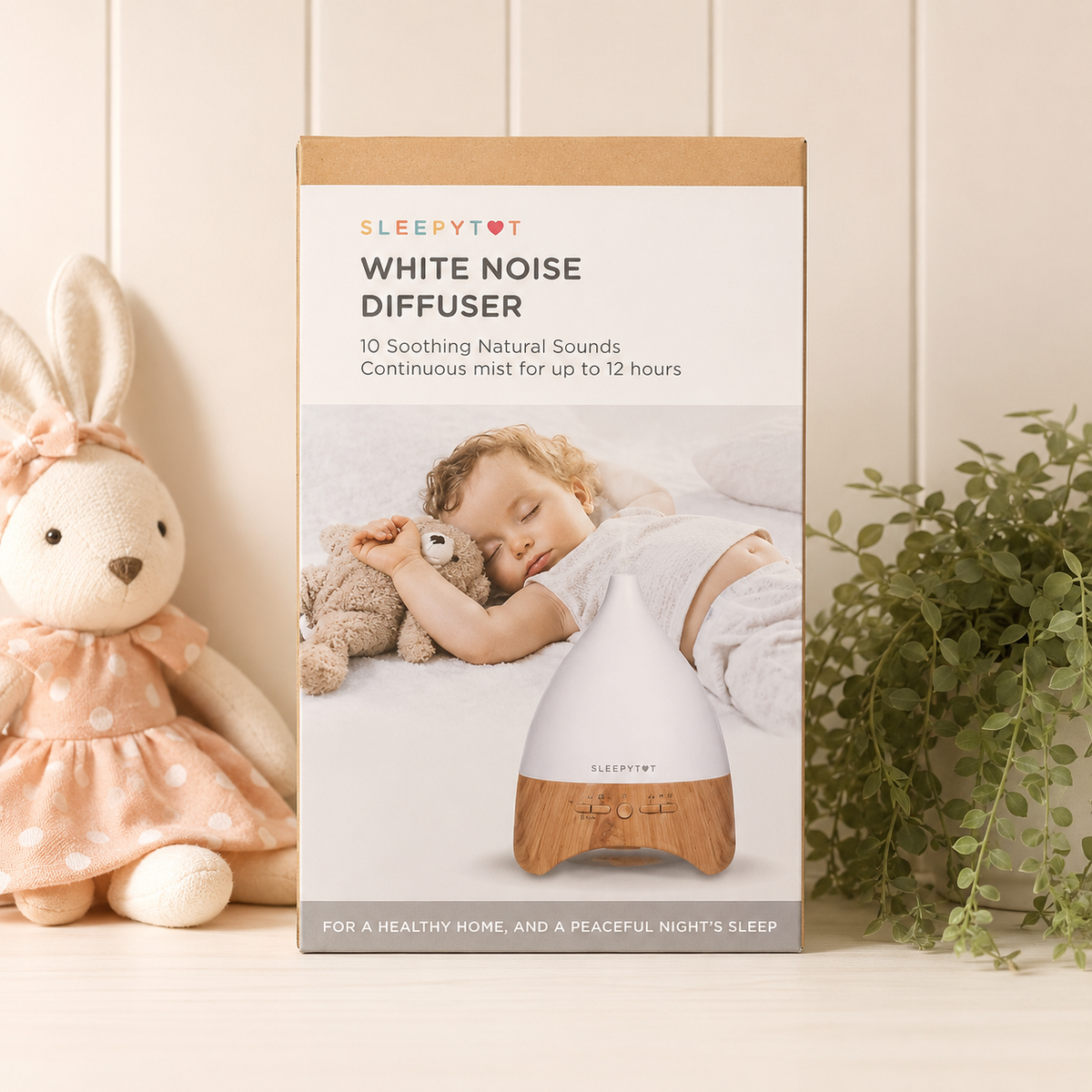 Sleepytime white noise diffuser packaging with a child sleeping and a rabbit toy on a light wooden floor.