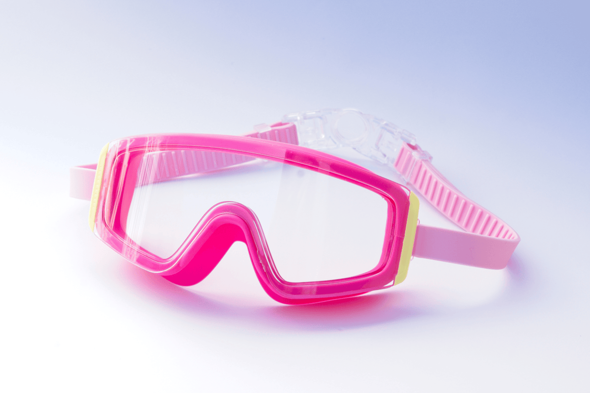 Pink Kids swim goggles with Yellow accents on a light blue background