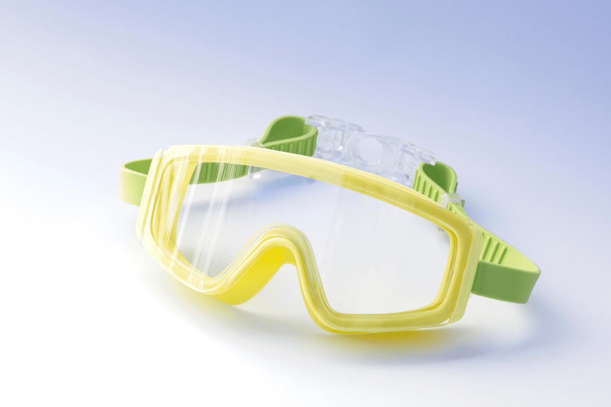 Yellow Kids swim goggles with green accents on a light blue background