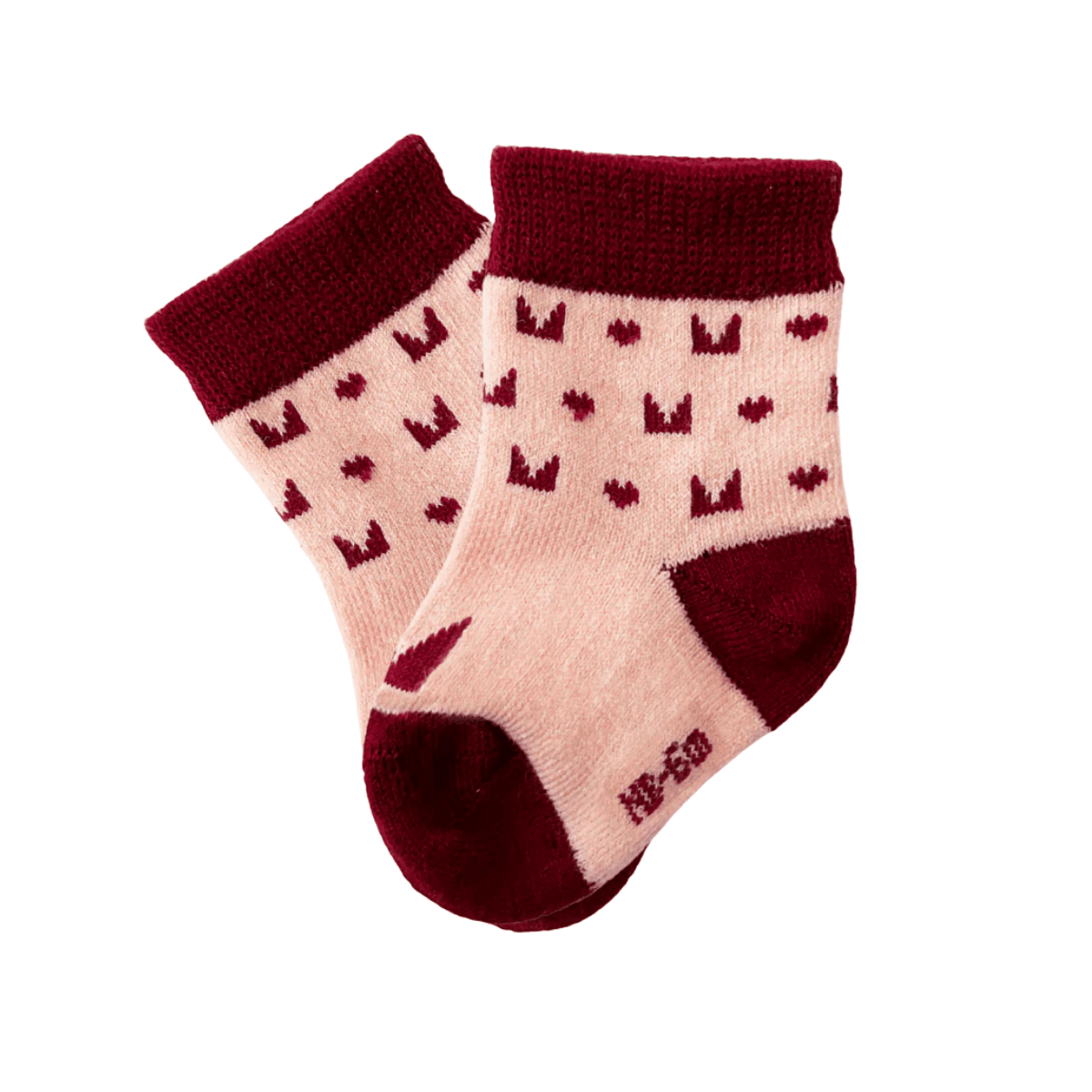 Pair of baby socks with red hearts on a beige background