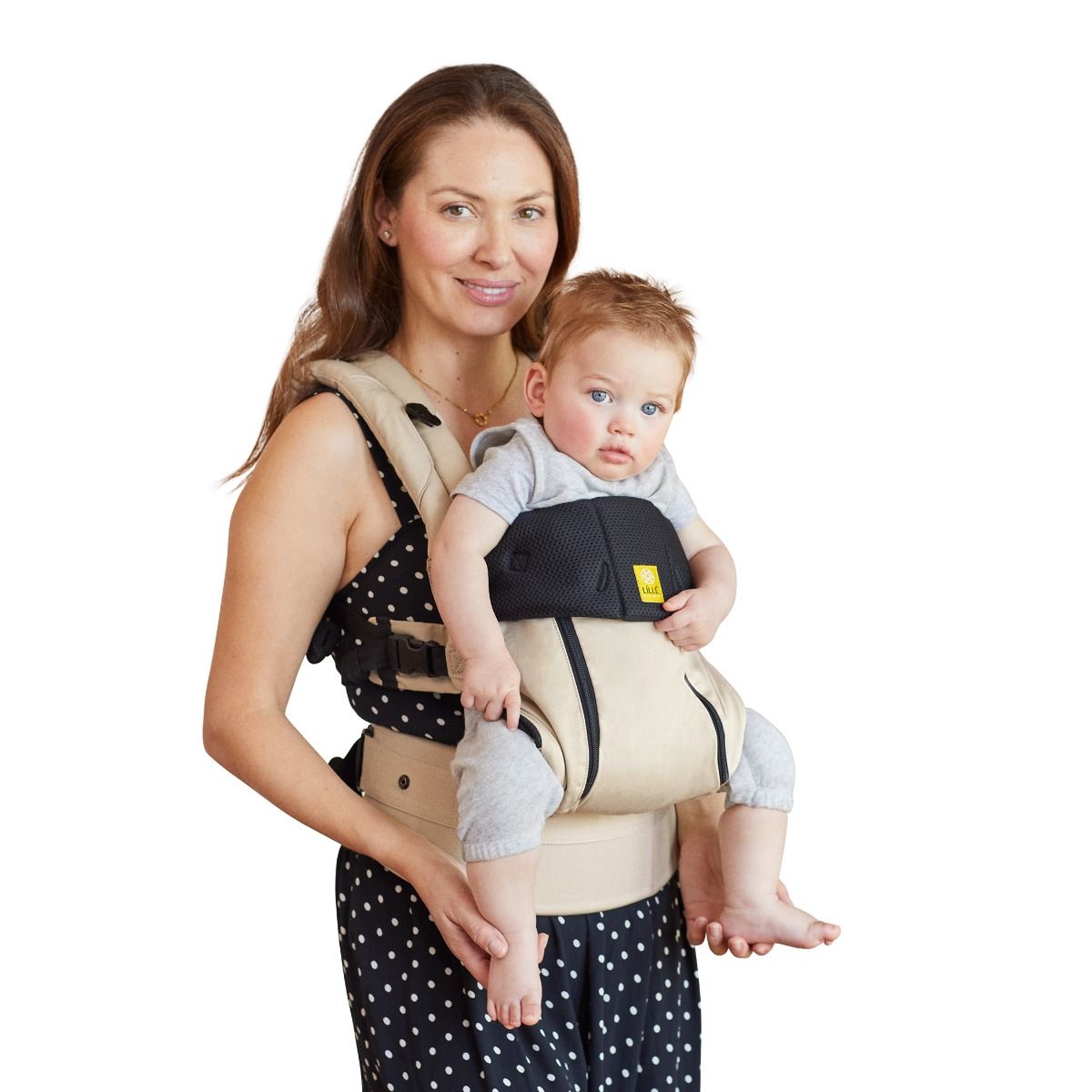 Woman holding a baby in a carrier against a white background