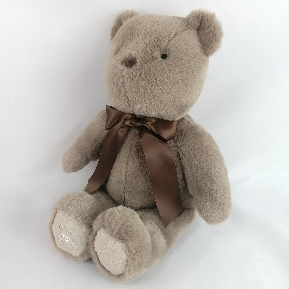 Plush bear toy with a brown bow. Has heart that records a short message or your babies heartbeat while in utero.