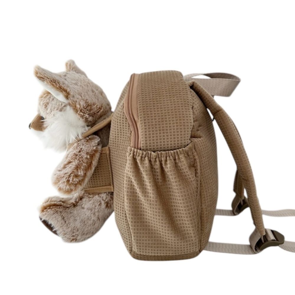 The side of the chai baby backpack showing the waterbottle space and the material of the bag.