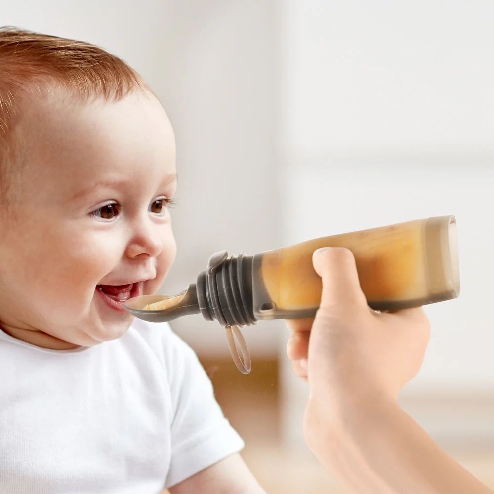 Baby eating from the Haakaa silicone pouch.