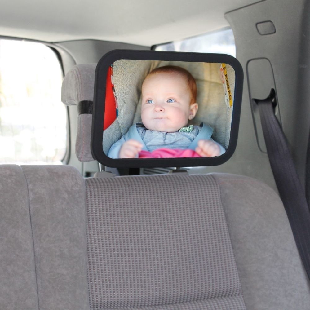 The baby view mirror attached to the back the back seat showing the baby in the reflection. The point of view from what the parent would be seeing.